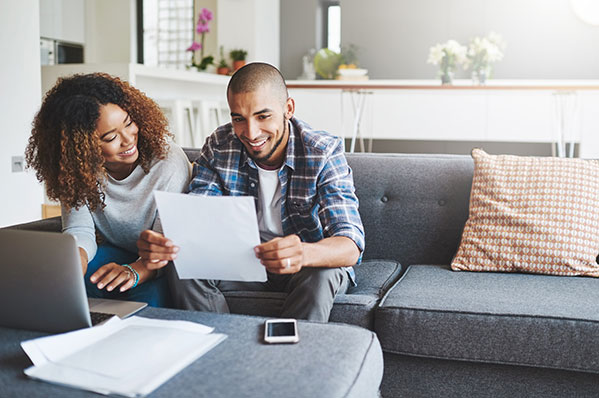 Young couple looking at paper on couch