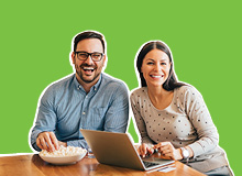 business plan smart goals smiling couple sitting at the table looking at their laptop