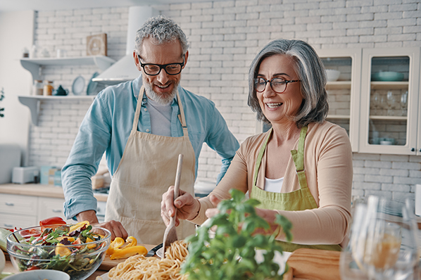 retired couple cooking healthy dinner in kitchen