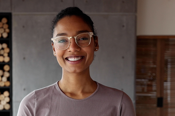 image of a confident smiling young black woman wearing glasses and looking at the camera