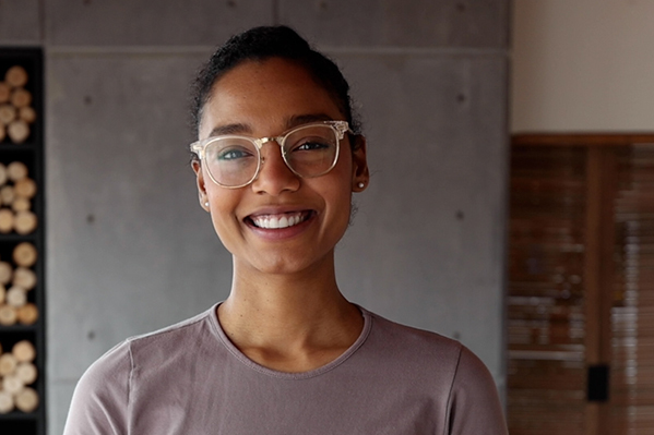 A smiling woman wearing reading glasses 