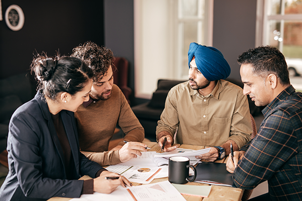 Members meet with two advisors and they discuss their finances over coffee.