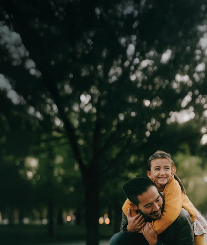 A man carrying his daughter on his back