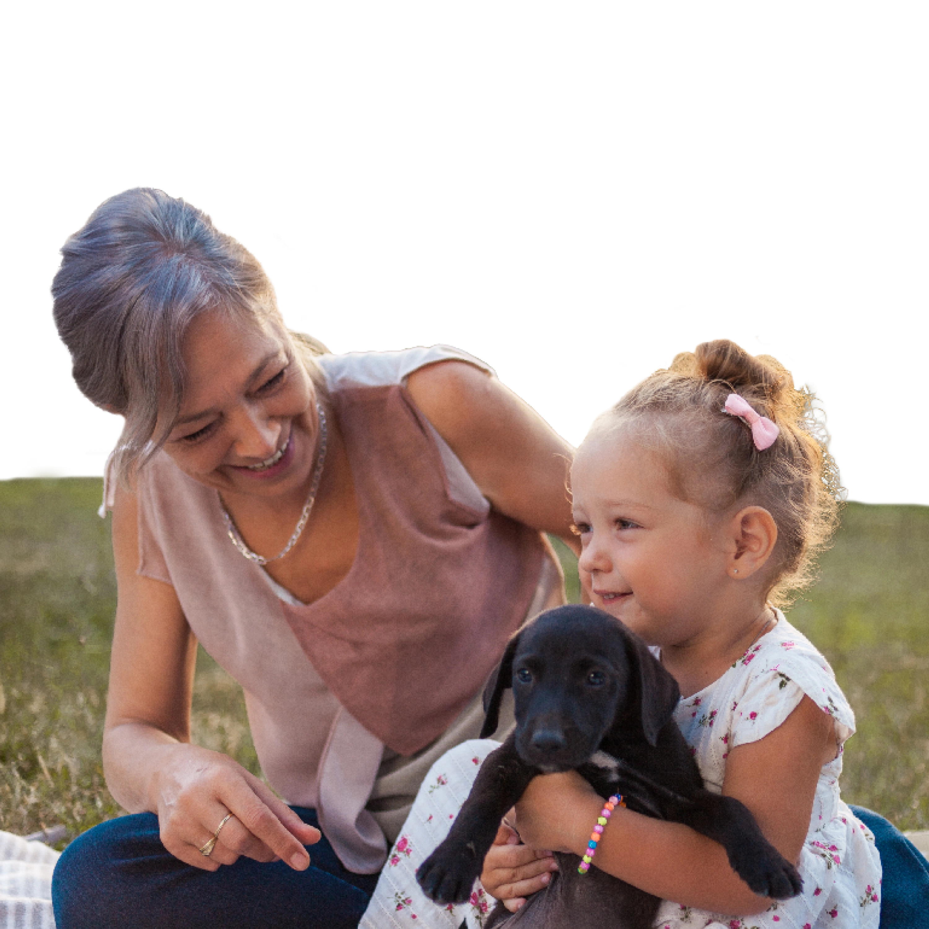 A woman and a child playing with a puppy