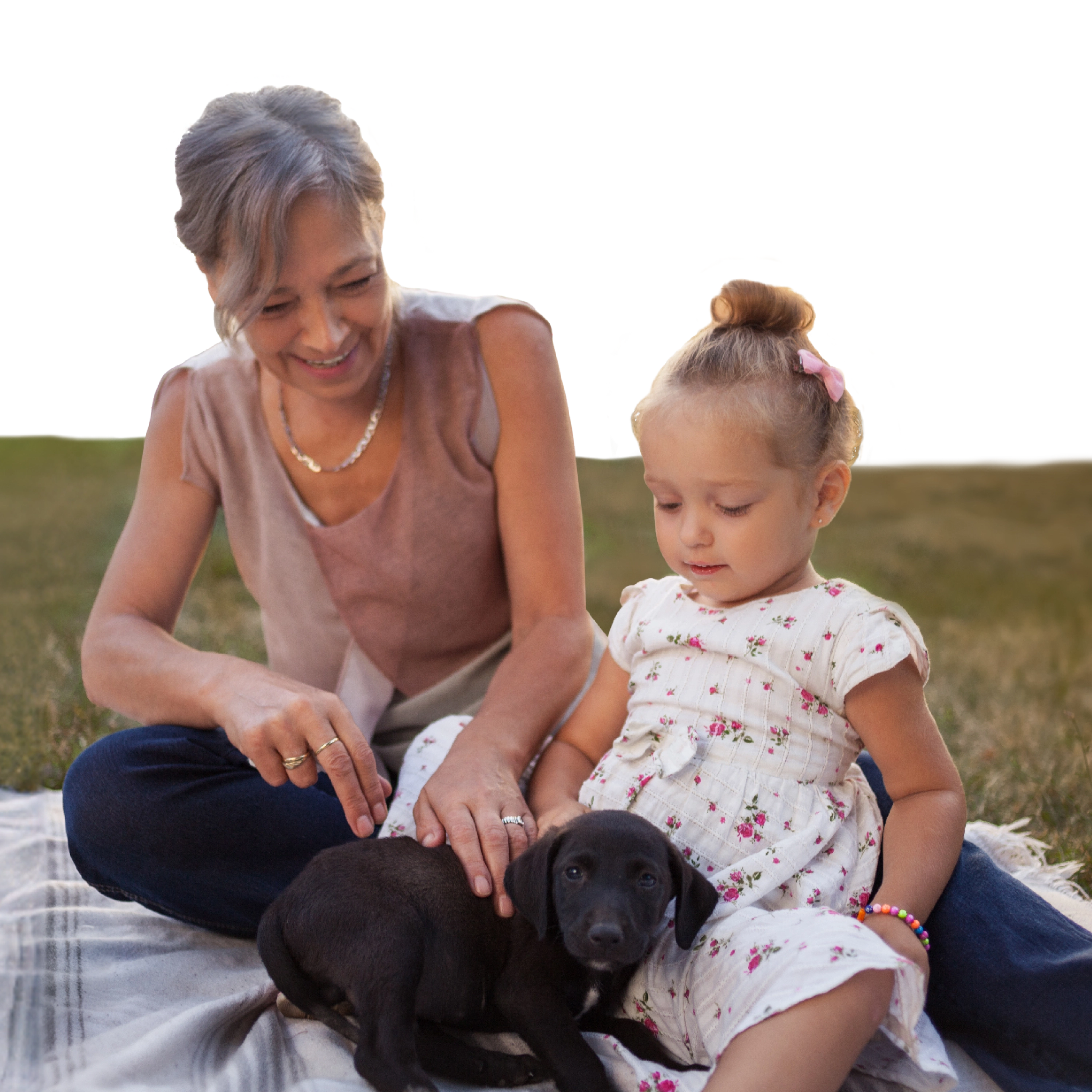 A woman and a child playing with a puppy