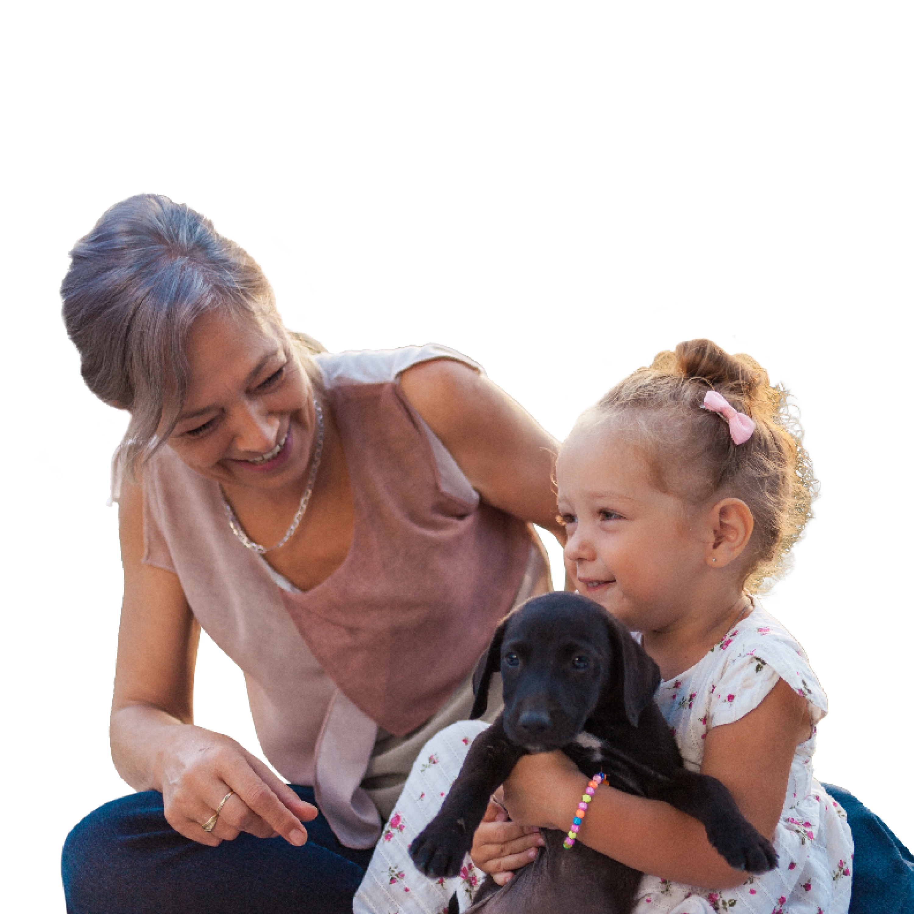 A woman and a child playing with a puppy
