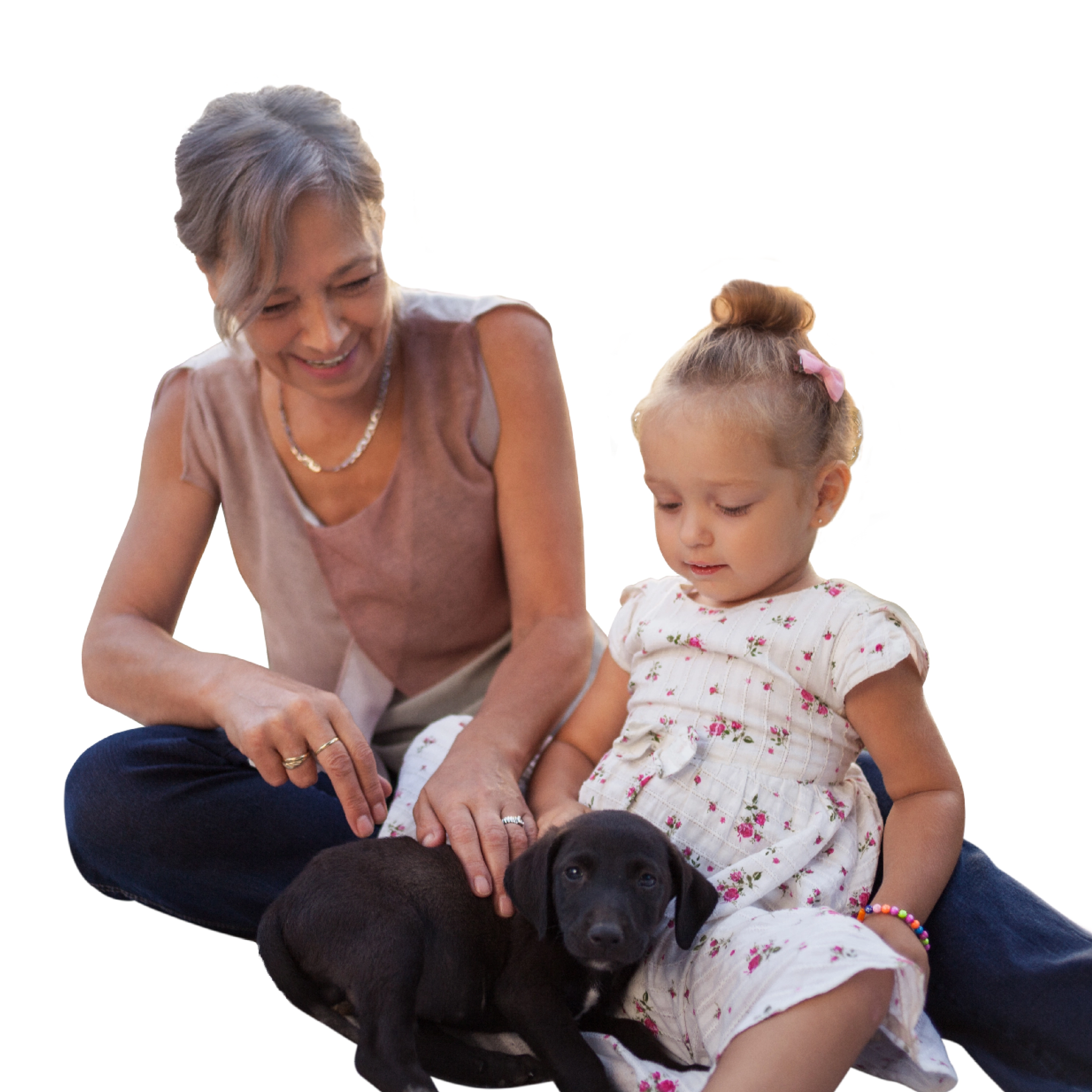 A woman and a child playing with a puppy