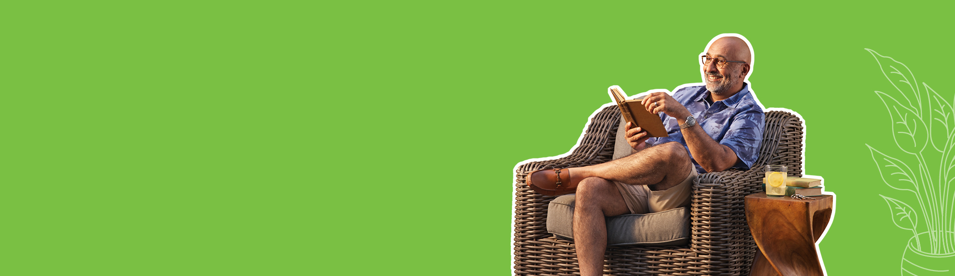 older well to do man smiling holding a book on his resort home patio