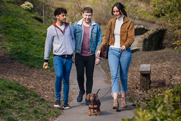 Three friends on a walk with a dog