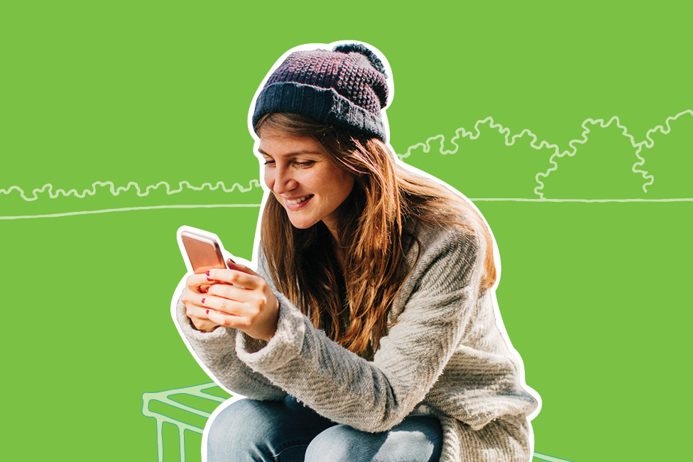 young woman sitting on a bench with a smartphone, wearing a toque