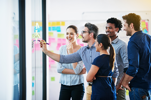 group of employees collaborating at the white board