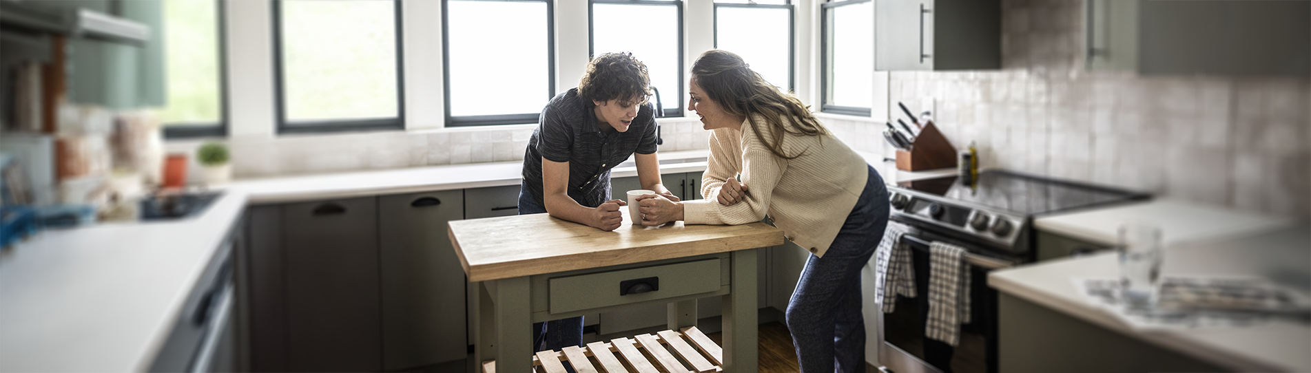 A couple having a conversation at the kitchen island
