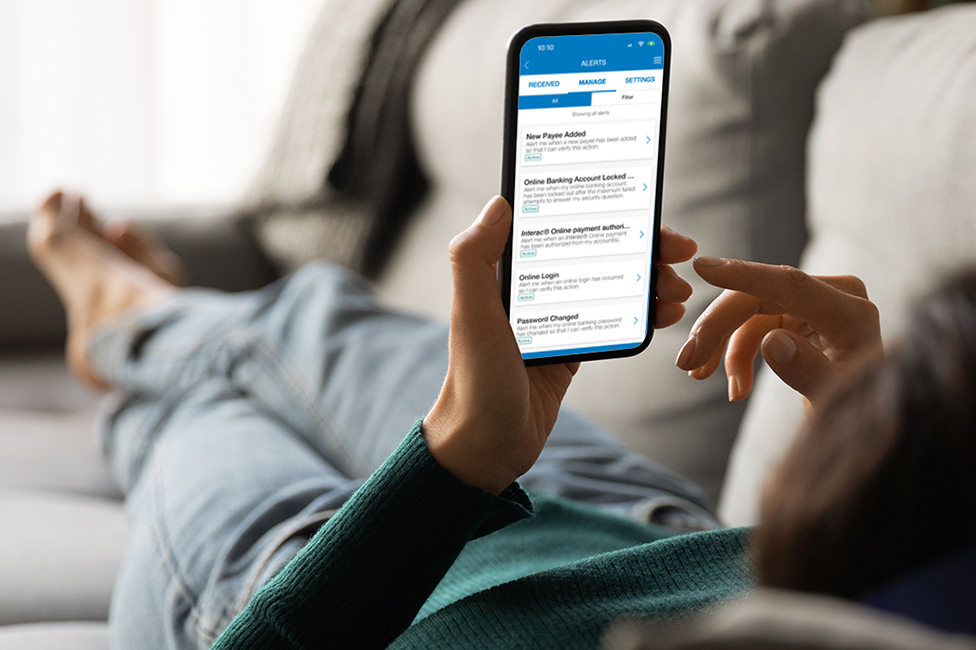 woman lying on couch, setting up mobile banking alerts